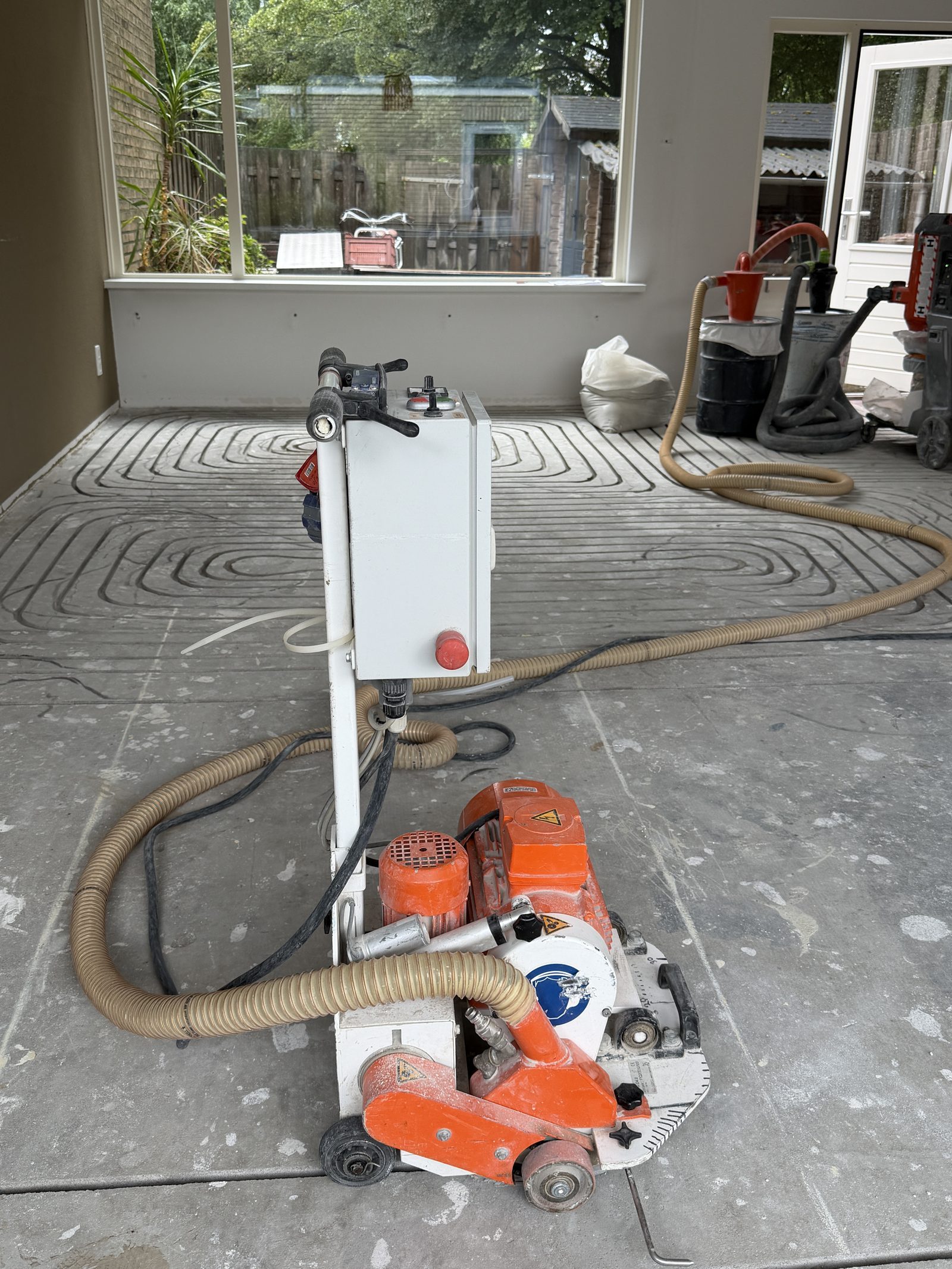 Onze freesmachine actief aan het werk — ingefreesde vloerverwarmingslussen met directe stofafzuiging