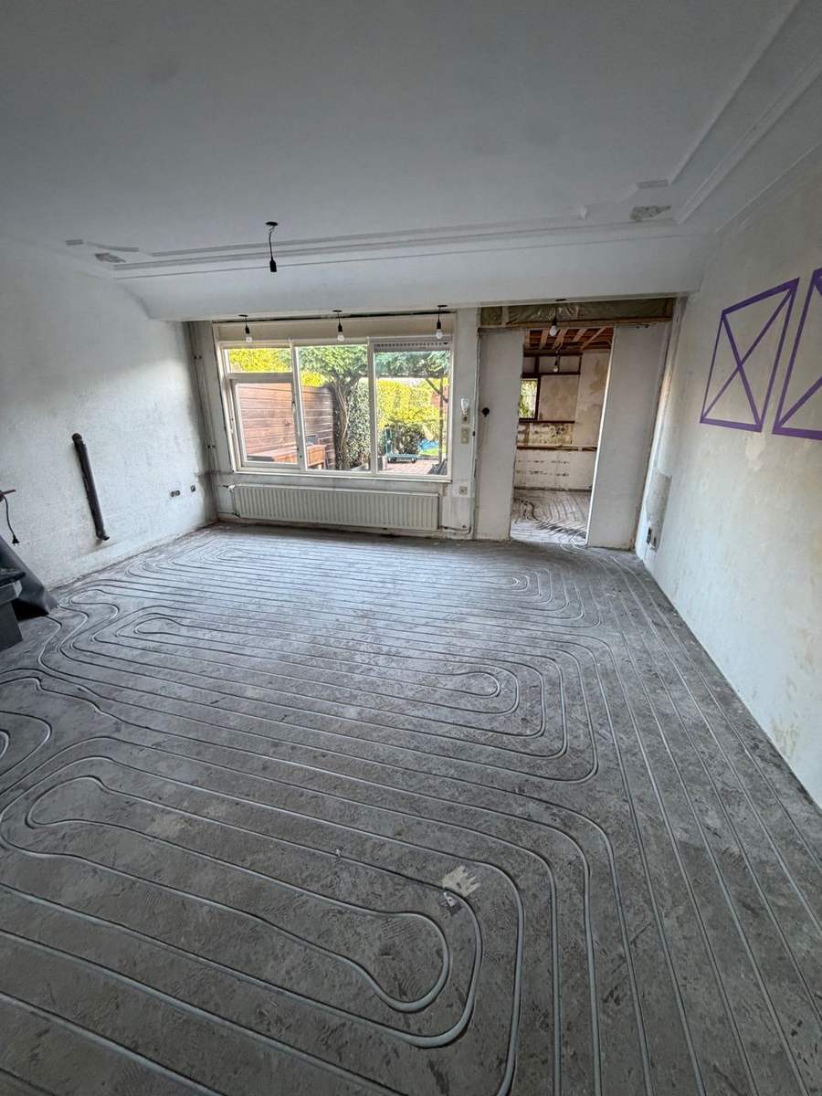 Ingefreesde vloerverwarming in de zandcement dekvloer van de woonkamer in Almere, met zicht op de tuin