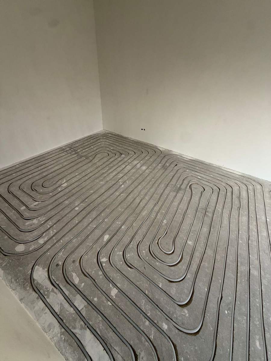 Strakke freessleuven met 16 mm vloerverwarmingsbuis op 100 mm hart-op-hart in zandcement, Amersfoort