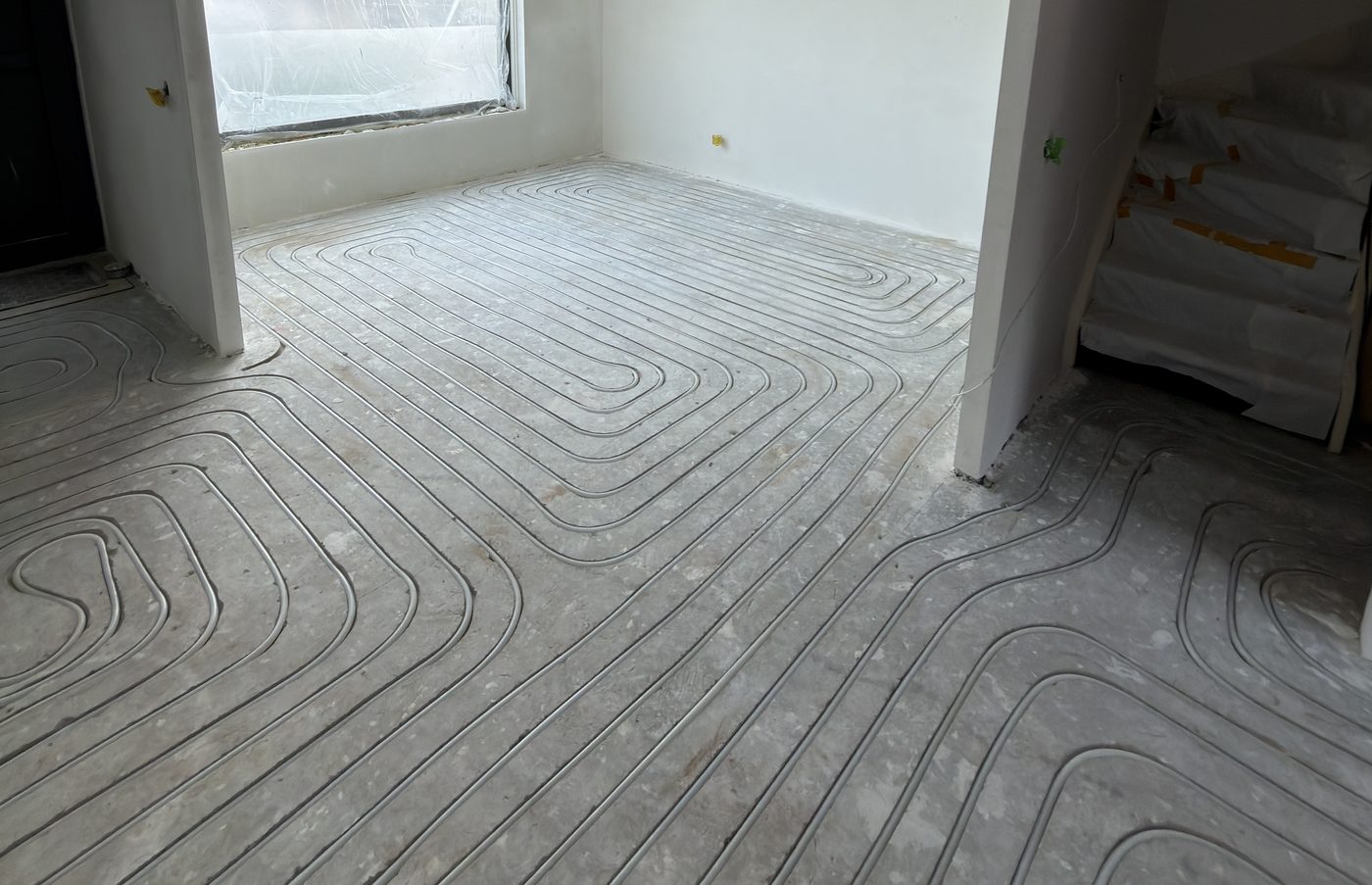 Ingefreesde vloerverwarming in de zandcement dekvloer van de woonkamer in Duiven